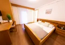 Gemütliches Doppelzimmer mit hellem Holzbett, Schreibtisch, TV und Laminatboden