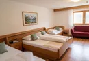 Geräumiges Familienzimmer mit Sofa und Alpenbild an der Wand im Sarntal
