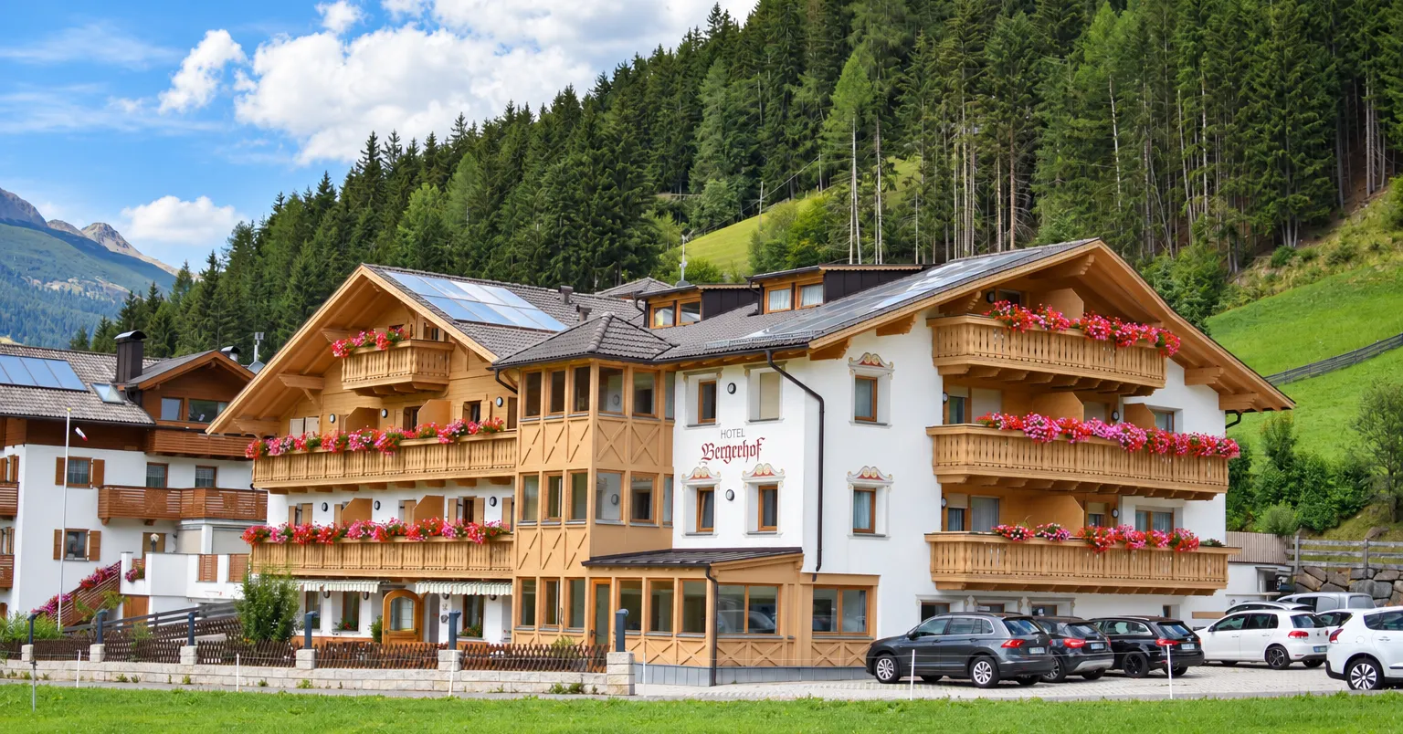 Almhotel Bergerhof mit Holzbalkonen in sonniger Berglage im Sarntal