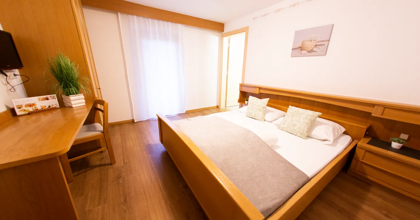 Gemütliches Doppelzimmer mit hellem Holzbett, Schreibtisch, TV und Laminatboden