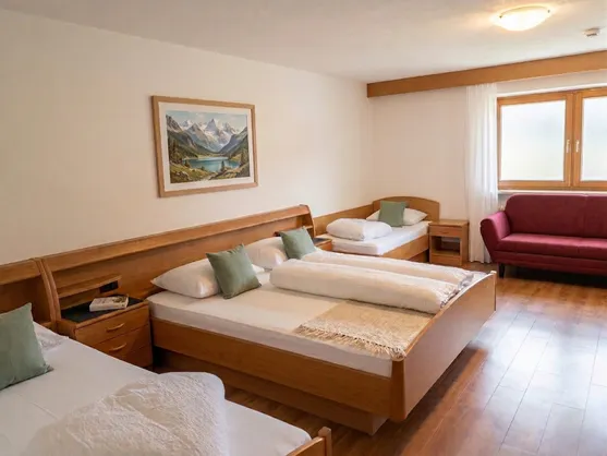 Geräumiges Familienzimmer mit Sofa und Alpenbild an der Wand im Sarntal