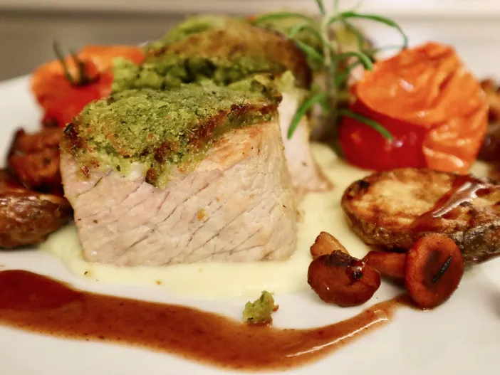 Rosa gebratenes Kalbsfleisch mit Kräuterkruste, Bratkartoffeln und cremiger Sauce