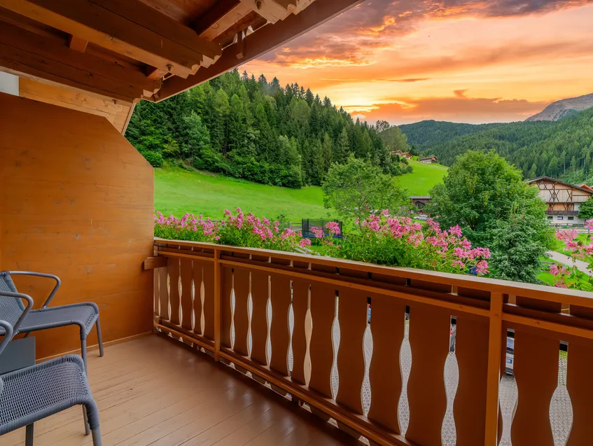 Überdachter Balkon mit Holzgeländer, Bergpanoramablick ins Sarntal und Geranien