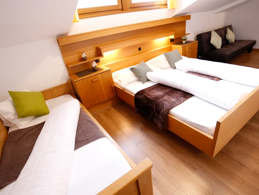 Familienzimmer unterm Dach mit Doppelbett, Einzelbett und gemütlicher Beleuchtung