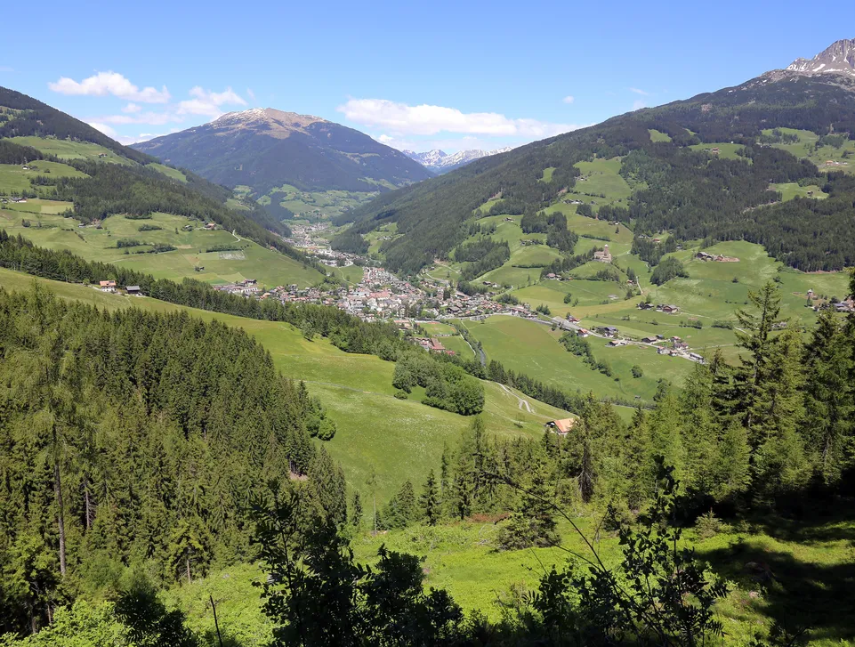 Panoramablick über das grüne Sarntal mit dem Dorf Sarnthein zwischen bewaldeten Berghängen